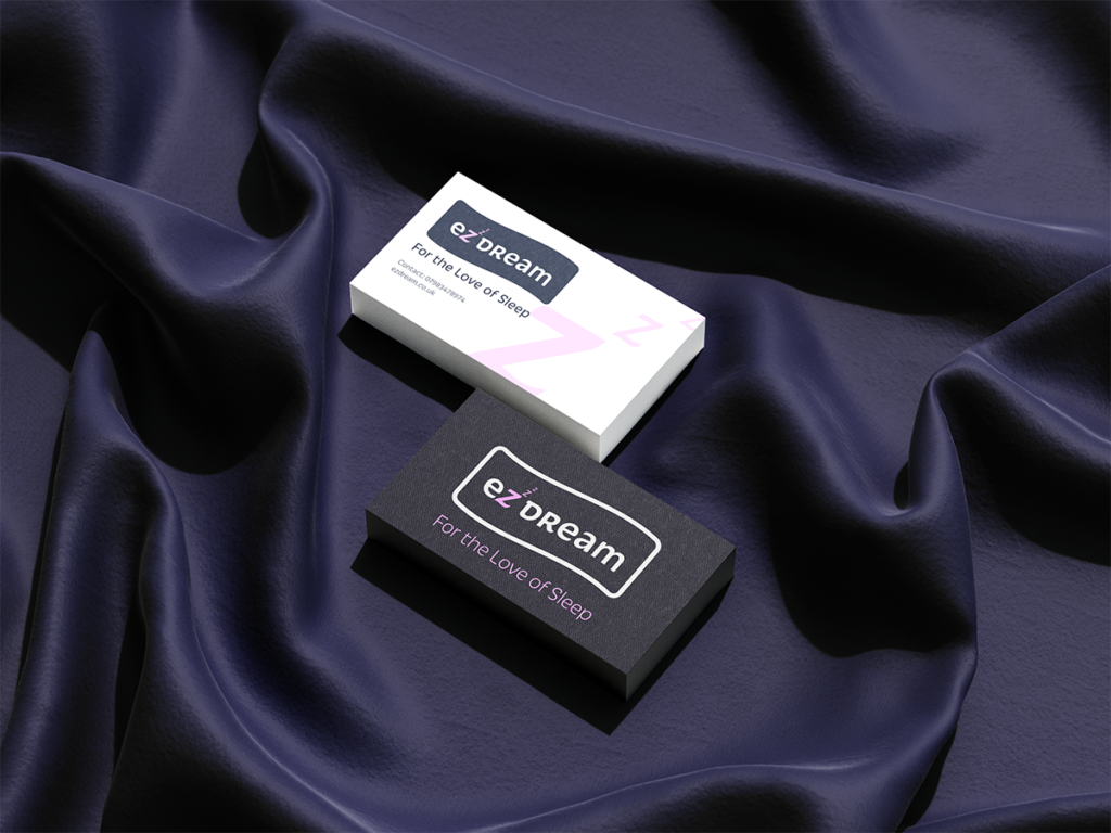 Business card with ezDream logo on. Both sides lying on a dark navy silky blanket.